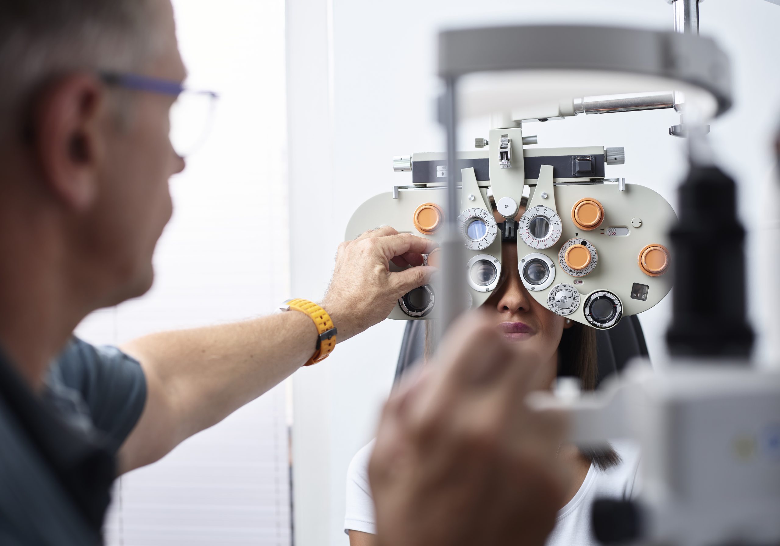 Optometrist examining young woman's eye