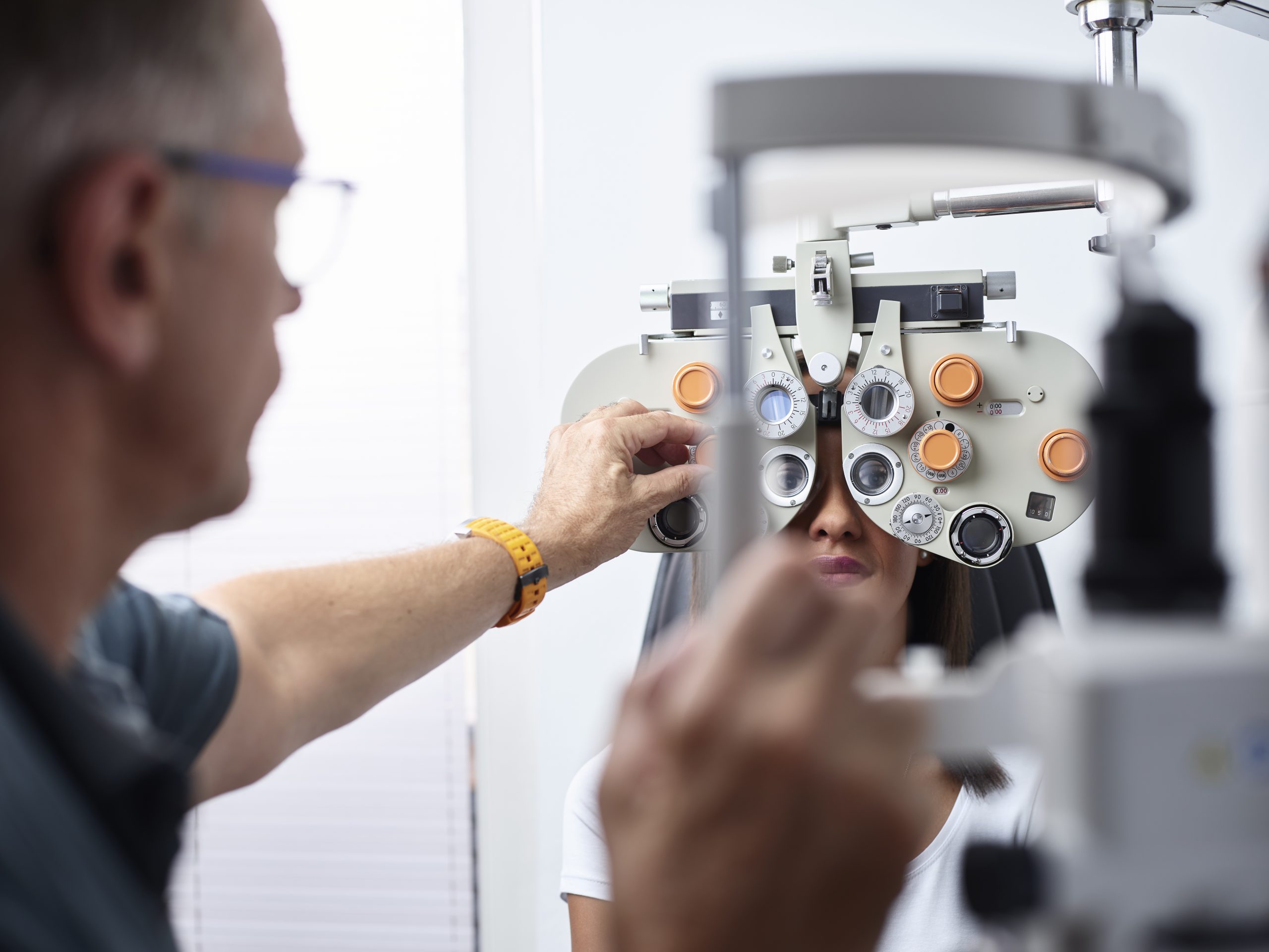 Optometrist examining young woman's eye Optometrist examining young woman's eye